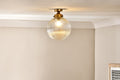 Lampada da soffitto per bagno Nkuku Konnie in ottone con globo in vetro rigato